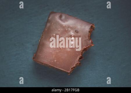 Eine gebissene Scheibe Schokoladenbrownie Draufsicht. Schokoladenbrownie auf schwarzem Hintergrund. Köstliche hausgemachte Schokoladendessert. Behalten Sie Ihre Ernährung bei und verlieren Sie w Stockfoto
