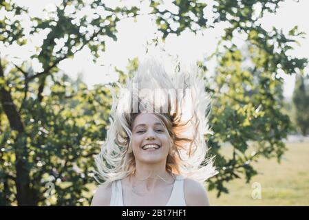 Porträt der blonden jungen Frau mit bläserem Haar im Sommer Stockfoto