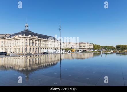 Frankreich, Gironde, Bordeaux, klarer blauer Himmel und Place de la Bourse, die sich im Miroir dEau Pool spiegeln Stockfoto