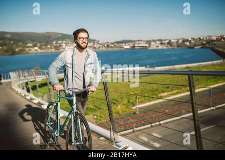 Junger Mann pendelt in der Stadt mit seinem Fixie-Fahrrad Stockfoto