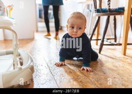 Zu Hause krabbelt ein kleiner Junge auf den Boden Stockfoto