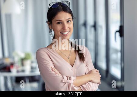 Geschäftsfrau mit verschränkten Armen in einem Büro Stockfoto