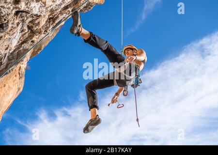 Kletterweibchen abseilen von der Felswand Stockfoto
