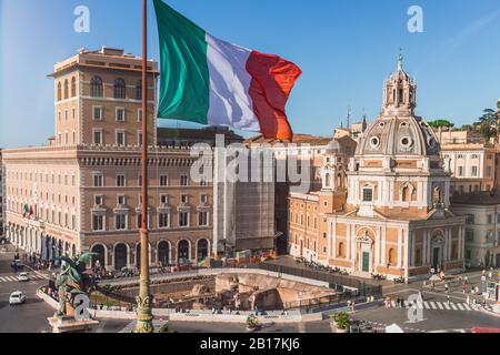 Italien, Rom, italienische Flagge flattert gegen Palazzo Bonaparte und Santa Maria di Loreto Stockfoto