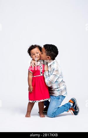 Junge küssen seine kleine Schwester Stockfoto