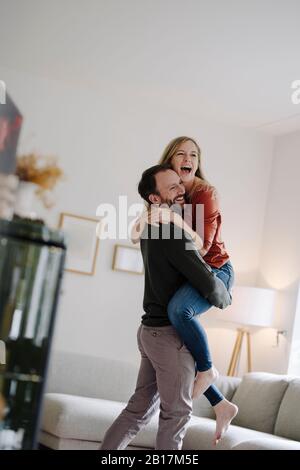 Mann hebt und umarmt seine jubelnde Frau Stockfoto