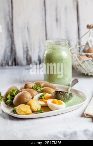 Teller mit Kartoffeln mit gekochten Eiern, Petersilie und Salsa verde Sauce Stockfoto