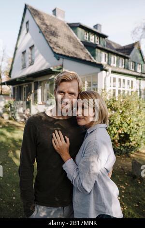 Portrait von lächelnden Paar steht vor ihrem Haus Stockfoto