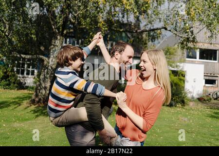 Eltern und Sohn haben Spaß und spielen im Garten Stockfoto