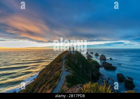 Neuseeland, Ozeanien, Südinsel, Southland, Otago, Southern Scenic Road, Cape Nugget Point, Nugget Point Leuchtturm bei Sonnenaufgang Stockfoto