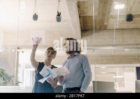 Unternehmer und Geschäftsfrau, die an einem Projekt im Büro arbeiten Stockfoto
