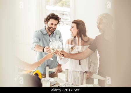 Familie und Frineds beim gemeinsamen Mittagessen klirrrende Weingläser Stockfoto