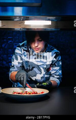 Küchenchef bereitet ein Gericht in der Restaurantküche zu Stockfoto