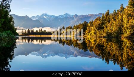 Neuseeland, Westland District, Fox Glacier, Lake Matheson spiegeln umliegenden Wald und entfernten Bergkette Stockfoto