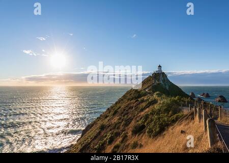 Neuseeland, Ozeanien, Südinsel, Southland, Otago, Southern Scenic Road, Cape Nugget Point, Nugget Point Leuchtturm bei Sonnenaufgang Stockfoto