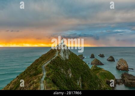 Neuseeland, Ozeanien, Südinsel, Southland, Otago, Southern Scenic Road, Cape Nugget Point, Nugget Point Leuchtturm bei Sonnenaufgang Stockfoto