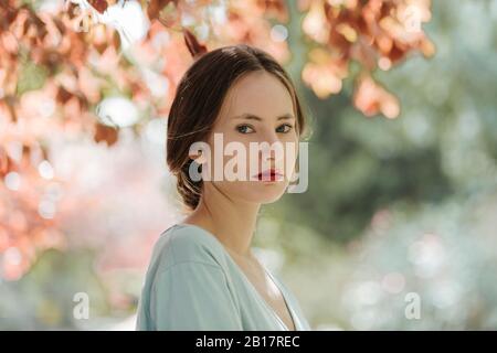 Porträt der jungen Frau mit roten Lippen in der Natur Stockfoto