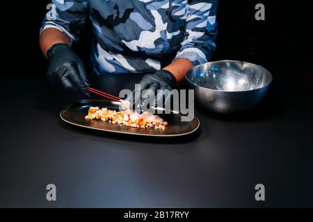 Nahaufnahme des Küchenchefs, der ein Gericht in der Restaurantküche zubereitet Stockfoto