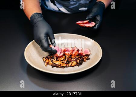 Küchenchef bereitet ein Gericht in der Restaurantküche zu Stockfoto