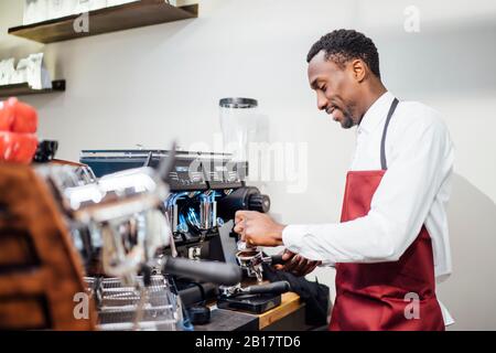 Lächelnder Barista, der einen Kaffee in einem Coffeeshop zubereitete Stockfoto