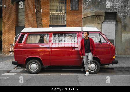 Reifer Mann am Schilf angelehnt Volkswagen Transporter am Straßenrand geparkt Stockfoto