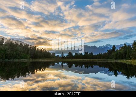 Neuseeland, Westland District, Fox Glacier, Wolken spiegeln sich bei Sonnenaufgang im Lake Matheson Stockfoto