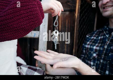 Nahaufnahme der Hand des Mädchens, die ihrem Vater Schlüssel gibt Stockfoto