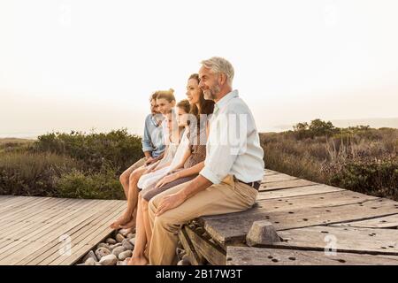 Große Familie, die den Sonnenuntergang auf einer Promenade genießt Stockfoto