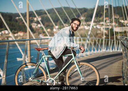 Junger Mann pendelt in der Stadt mit seinem Fixie-Fahrrad Stockfoto