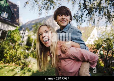 Mutter und Sohn haben Spaß und spielen im Garten Stockfoto
