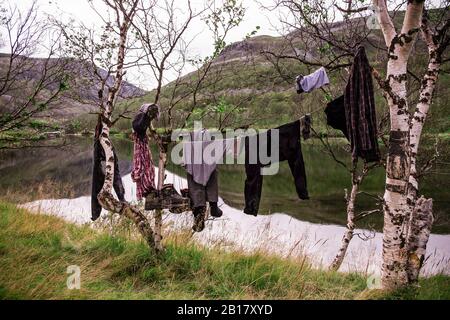 Wanderkleidung und Stiefel hängen an Wäscheleine auf dem Land, Lakselv, Norwegen Stockfoto