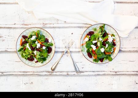 Teller mit Maissalat mit gerösteten Karotten, Rote Bete, rote Zwiebeln und Ziegenkäse Stockfoto