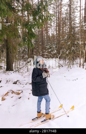 Lächelnde Frau auf Skiern im Winterwald Stockfoto