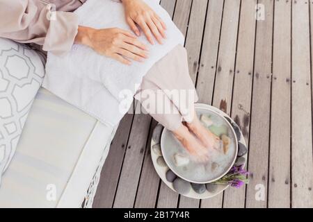 Nahaufnahme einer Frau, die ein Fußbad hat Stockfoto