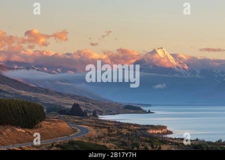 Neuseeland, landschaftlich reizvoller Blick auf den New Zealand State Highway 80, der sich im Morgengrauen am Ufer des Lake Pukaki entlang erstreckt, mit Mount Cook im Hintergrund Stockfoto