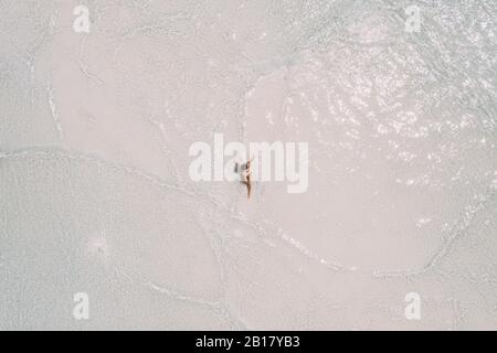 Frau, die auf einer Sandbank im Meer sitzt, Maguhdhuvaa-Insel, Gaafu Dhaalu Atoll, Malediven Stockfoto