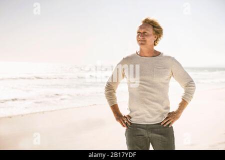 Porträt eines lächelnden Mannes, der am Strand steht Stockfoto