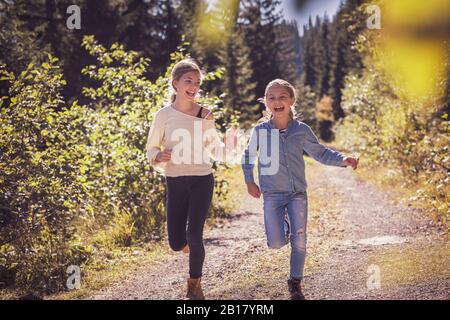 Mädchen laufen und Spaß auf einem Waldweg in der Landschaft Stockfoto