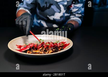 Küchenchef bereitet ein Gericht in der Restaurantküche zu Stockfoto