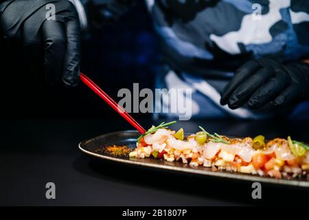 Nahaufnahme des Küchenchefs, der ein Gericht in der Restaurantküche zubereitet Stockfoto