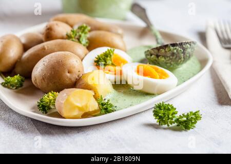 Teller mit Kartoffeln mit gekochten Eiern, Petersilie und Salsa verde Sauce Stockfoto