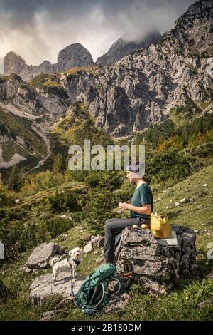 Frau mit Hund auf Wandertour am Wilden Kaiser mit Pause, Kaiser-Berge, Tyrol, Österreich Stockfoto