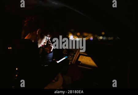 Junge Frau mit Smartphone in der Nacht Stockfoto