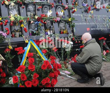 Kiew, Ukraine. Februar 2020. Ein Mann gibt Blumen in Erinnerung an die Euro-Maidan-Aktivisten oder "Helden der himmlischen Hundert", die während der Anti-Regierungs-Proteste 2014 im Zentrum von Kiew getötet wurden.die Ukrainer markieren den 6. Jahrestag der Maidan-Revolution oder Euromaidan-Revolution, bei der mindestens 100 Demonstranten getötet wurden. Credit: Sopa Images Limited/Alamy Live News Stockfoto