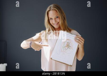 Porträt der blonden jungen Frau, die Papier mit scribbbling hält Stockfoto
