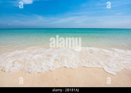 Weiche Blue Ocean Wave Am Sandy Beach. Blick auf den schönen tropischen Strand. Urlaubs- und Urlaubskonzept. Tropischer Strand. Stockfoto