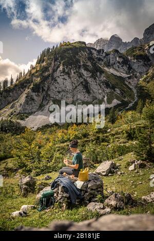 Frau mit Hund auf Wandertour am Wilden Kaiser mit Pause, Kaiser-Berge, Tyrol, Österreich Stockfoto