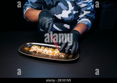 Nahaufnahme des Küchenchefs, der ein Gericht in der Restaurantküche zubereitet Stockfoto