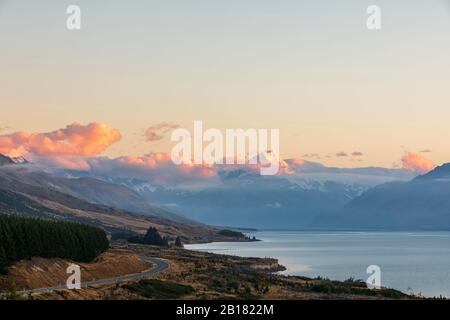 Neuseeland, landschaftlich reizvoller Blick auf den New Zealand State Highway 80, der sich im Morgengrauen am Ufer des Lake Pukaki entlang erstreckt, mit Mount Cook im Hintergrund Stockfoto