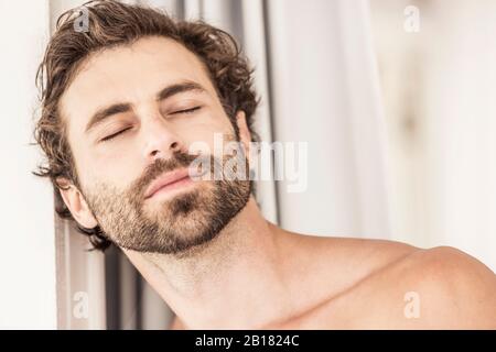 Porträt des jungen Mannes mit Bart, geschlossenen Augen Stockfoto